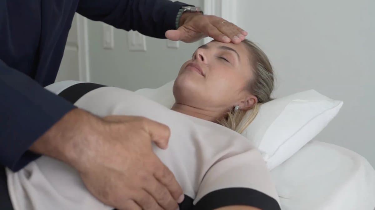 Marcelo Moreira aplicando Terapia Manual Evolutiva (TME) com toque leve na testa e no abdômen
